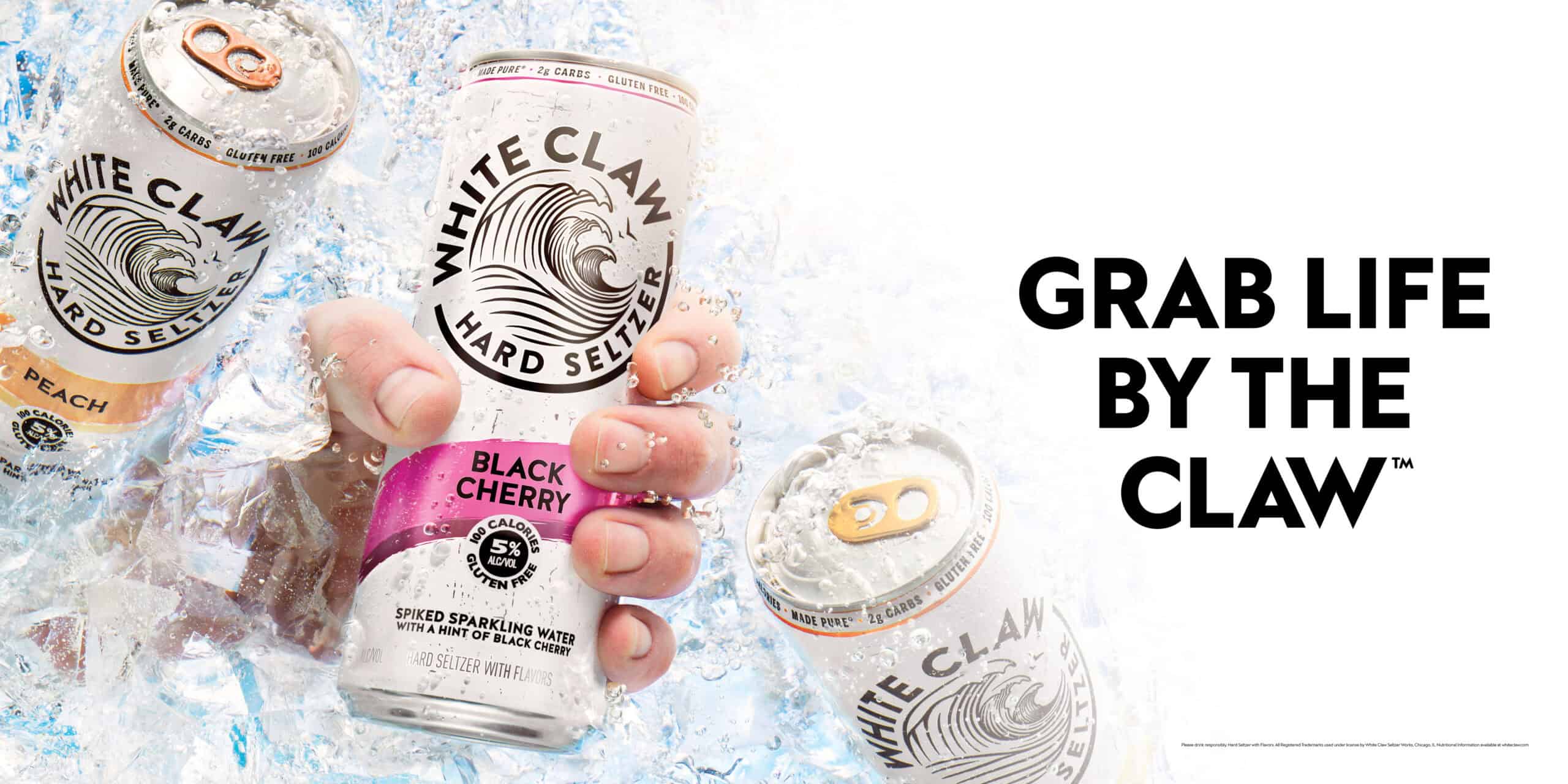 Black cherry can of White Claw being grabbed by a caucasian male hand in a cooler full of ice on a sunny day.