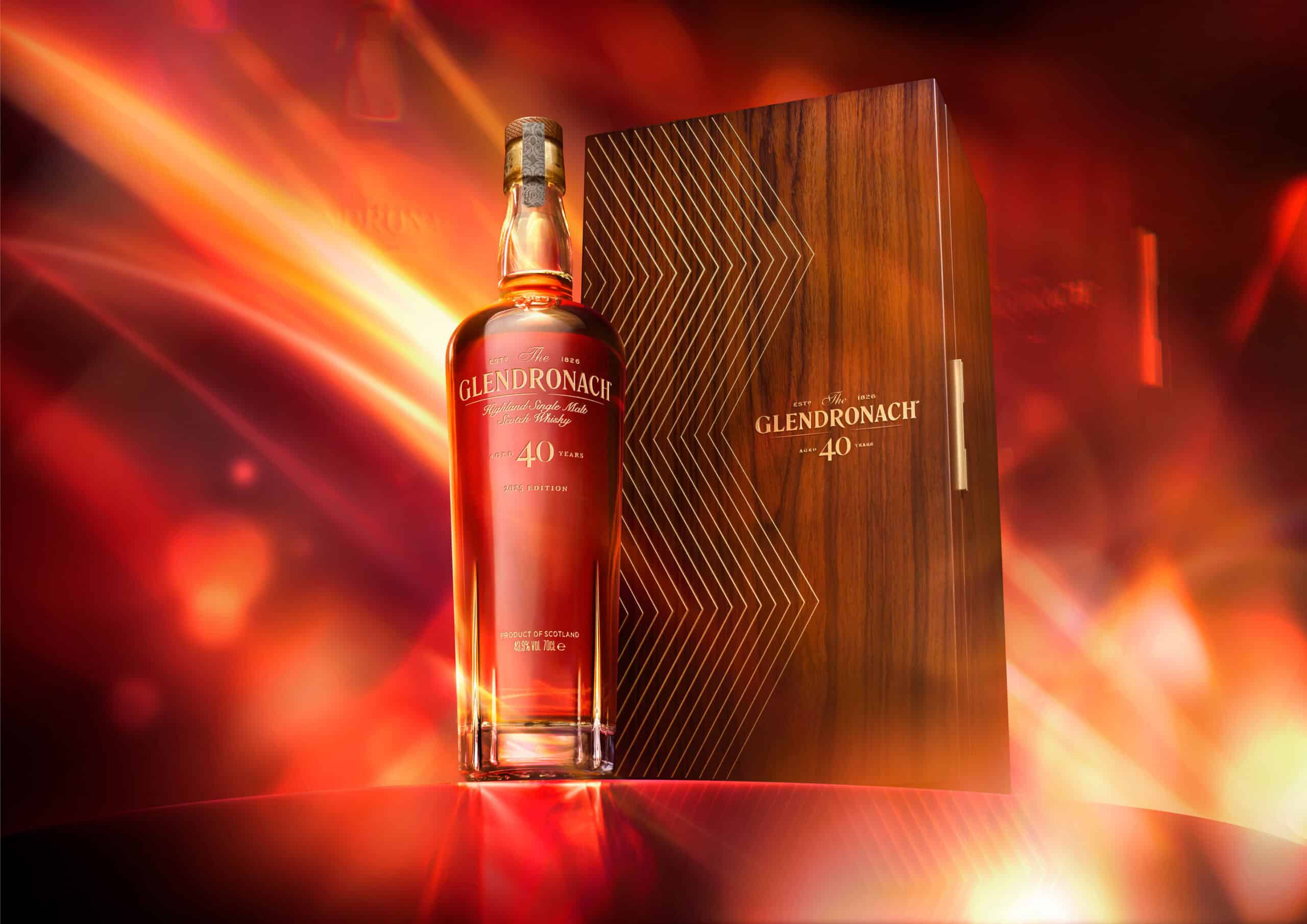 Whisky bottle sitting on a red plinth with a Glendronach oak wood box next to it. The camera angel is low to make the bottle look heroic.