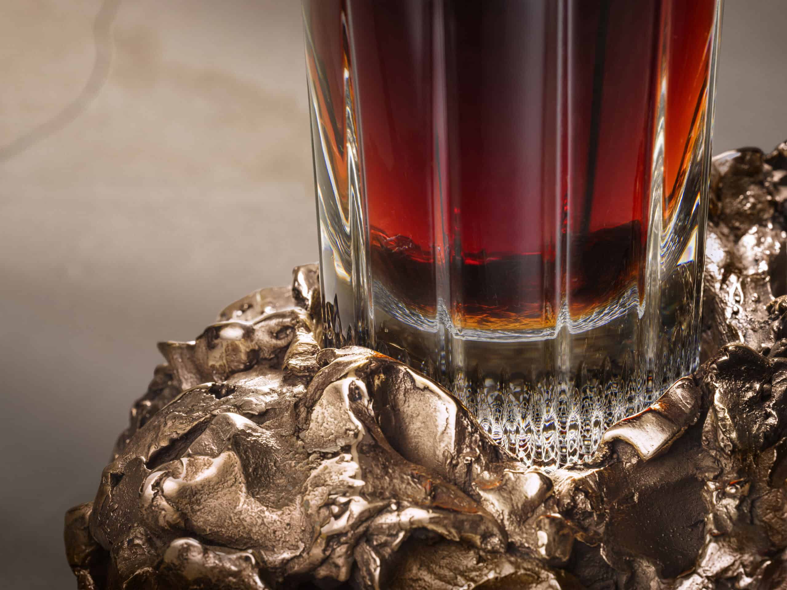 Close-up of the base of a bottle of whisky sitting in a bronze