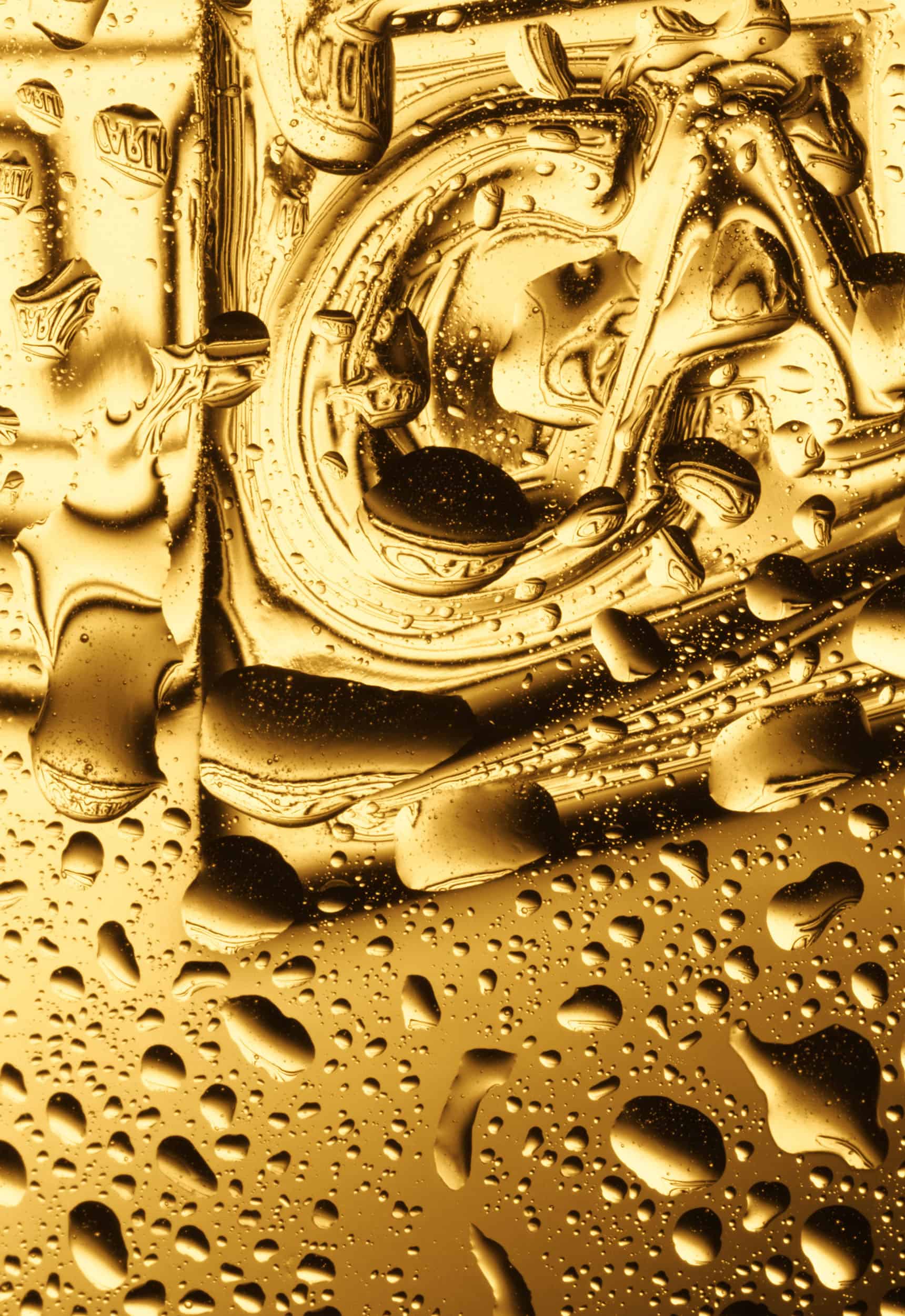 Macro photography of a chilled carling glass filled with golden beer and condensation on the outside. Shot by drinks photographer Jonathan Knowles