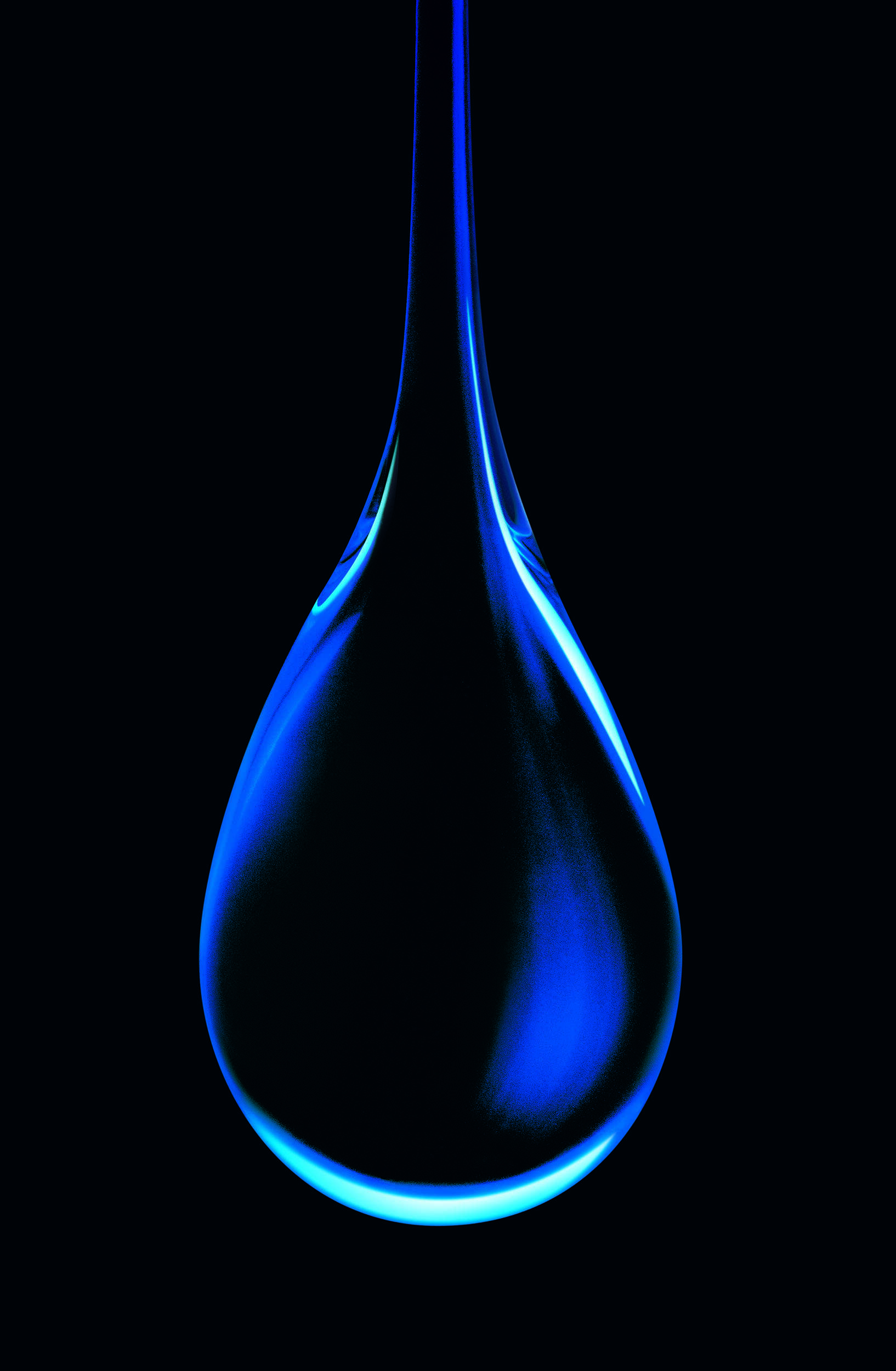 Macro image of a single droplet of blue liquid on a black background taken by liquid photographer Jonathan Knowles