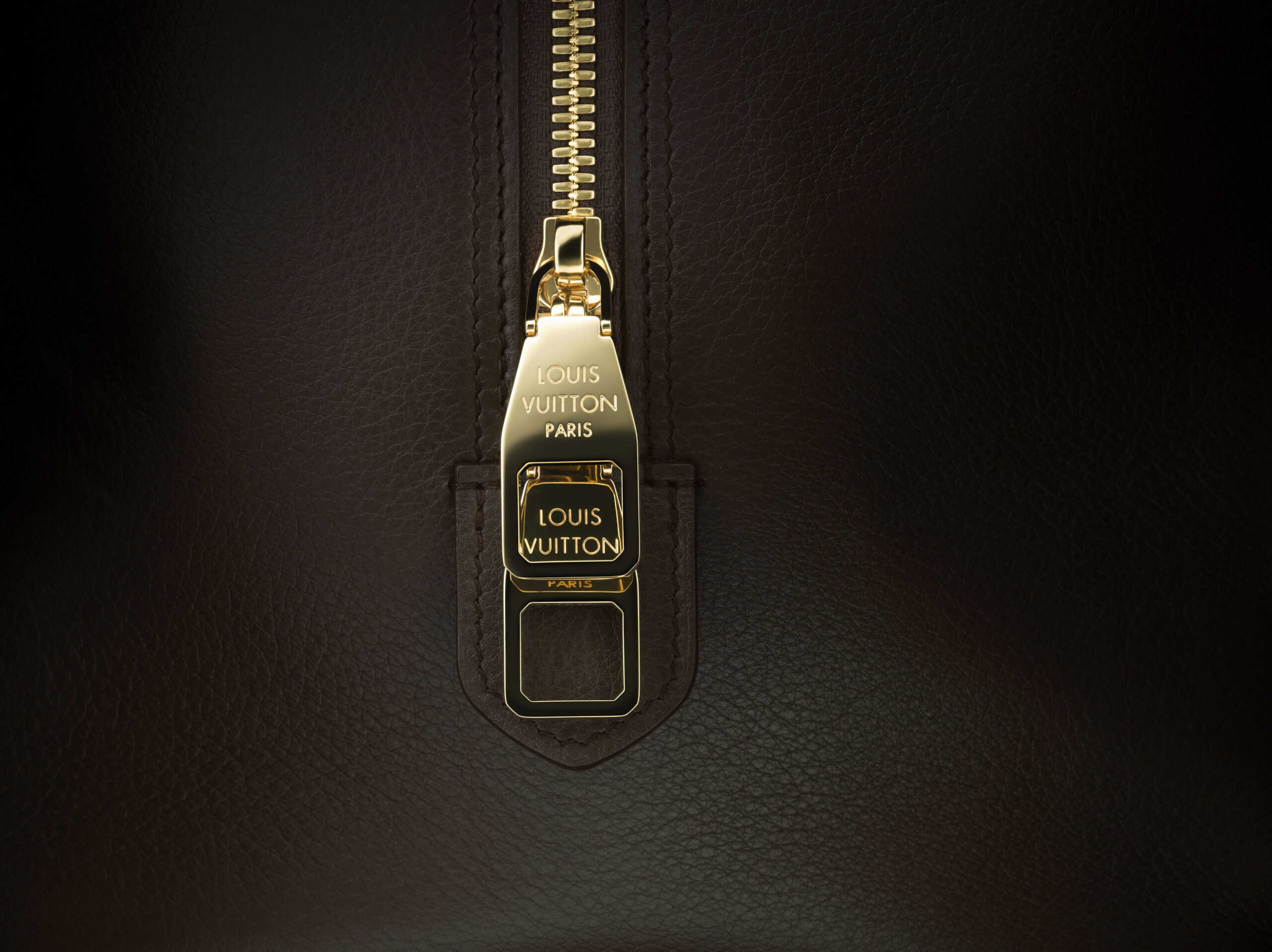 Macro image of a Louis Vuitton brown leather bag with a gold zip taken by still life photographer Jonathan Knowles